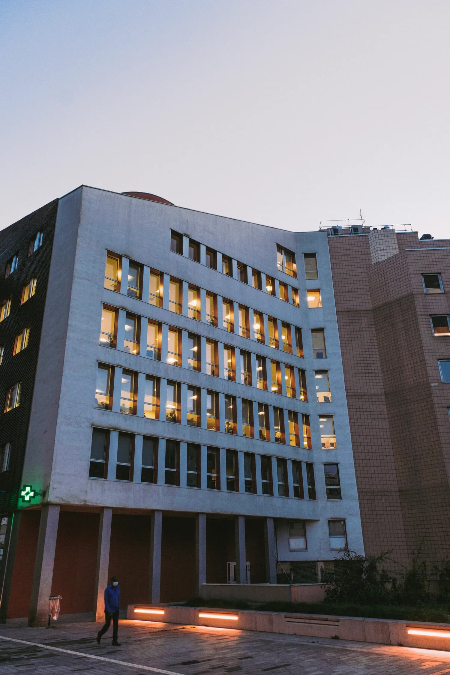 A modern hospital building entrance lit at dusk