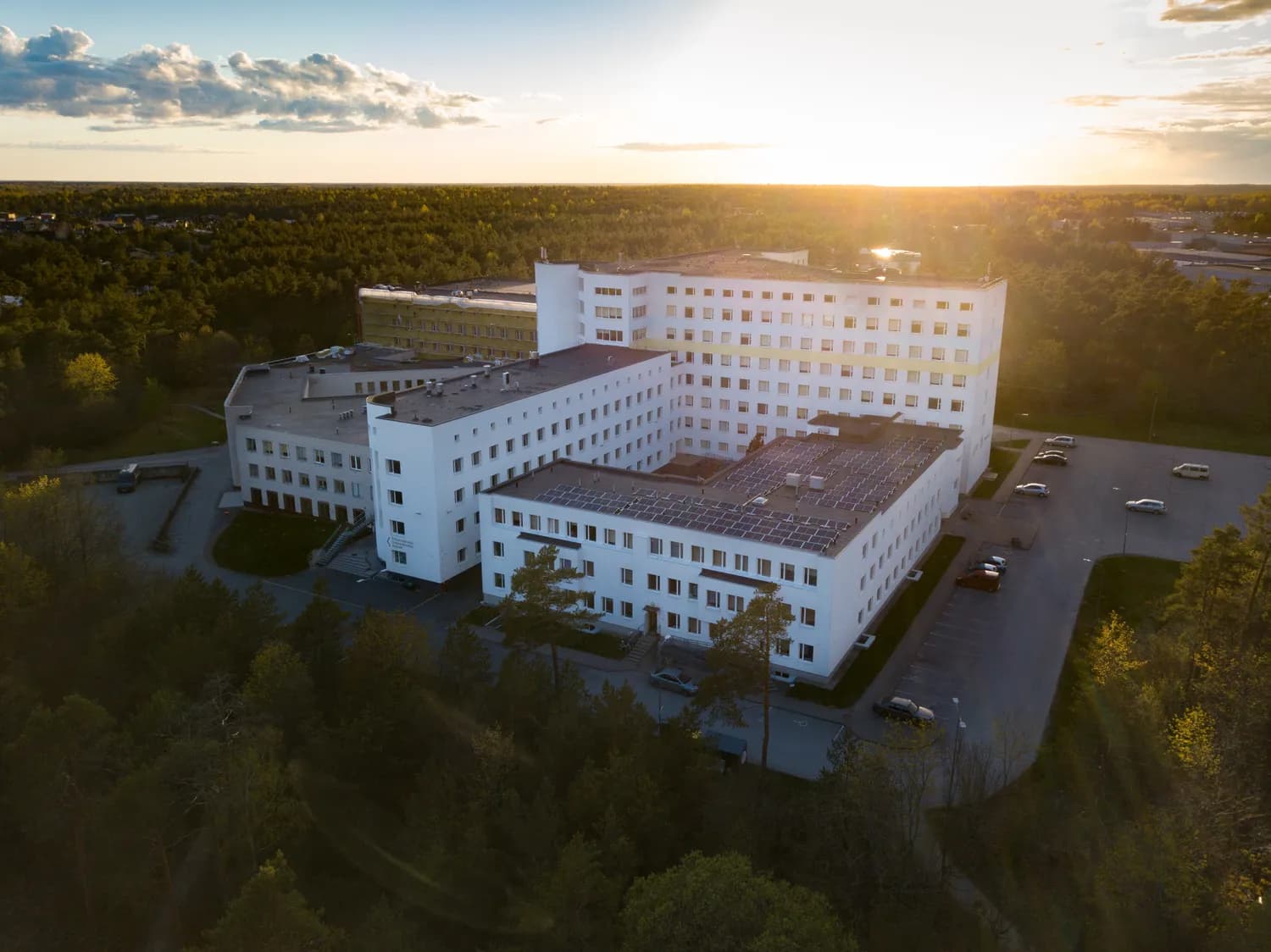 An aerial view of a modern hospital campus among greenery