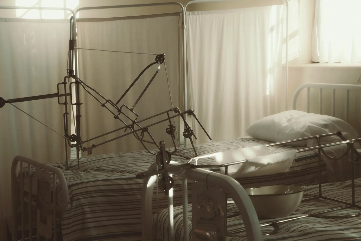 A made-up hospital bed in a calm, sunlit room